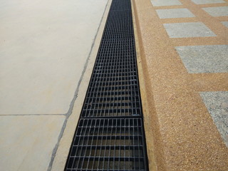 view of black metal Manhole cover on concrete ground side way texture background.