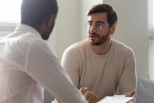 African counsellor sitting in front of patient listens his complaints