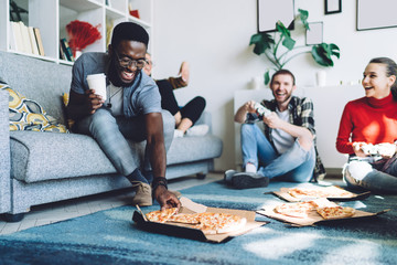 Multiracial friends eating pizza at home