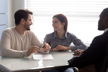 Couple and insurance agent during meeting ready to sign agreement