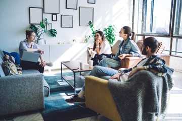 Young people sitting with laptop and paper cups