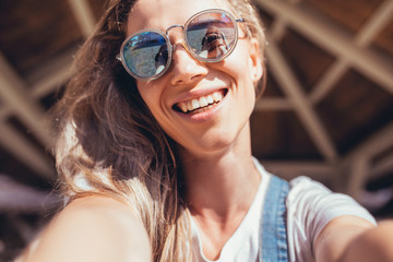 Close up portrait of a beautiful cheerful young female student taking a selfie or talking on video...