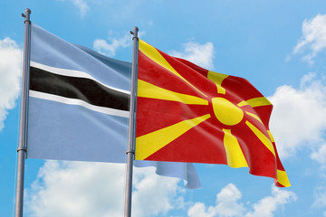 Macedonia and Botswana flags waving in the wind against white cloudy blue sky together. Diplomacy concept, international relations.