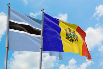 Moldova and Botswana flags waving in the wind against white cloudy blue sky together. Diplomacy concept, international relations.
