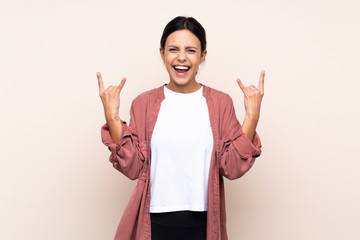 Woman over isolated background making rock gesture