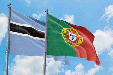 Portugal and Botswana flags waving in the wind against white cloudy blue sky together. Diplomacy concept, international relations.