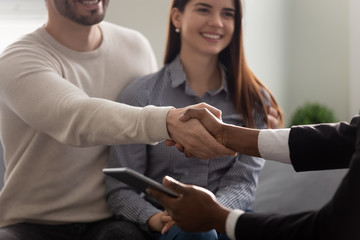 Fototapeta premium Property buyer and African realtor handshaking greeting each other