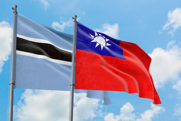Taiwan and Botswana flags waving in the wind against white cloudy blue sky together. Diplomacy concept, international relations.