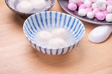 Fototapeta na wymiar Delicious tang yuan, yuanxiao in a small bowl. Traditional festive food rice dumplings ball with stuffed fillings for Chinese Lantern Festival, close up.