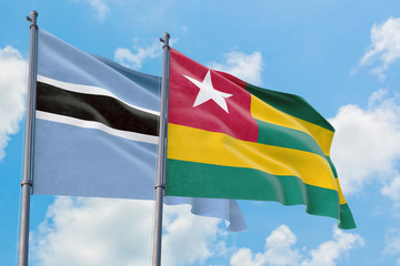 Togo and Botswana flags waving in the wind against white cloudy blue sky together. Diplomacy concept, international relations.