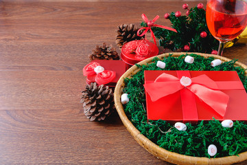 Red gift box in a basket at Christmas and a celebration drink