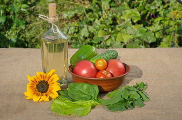 Sunflower oil, fresh vegetables and herbs on the table