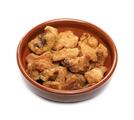 Pork cracklings, greaves in clay bowl isolated on white background