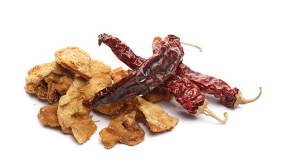 Pork cracklings, greaves with dry spicy peppers isolated on white background