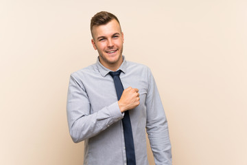 Young blonde businessman over isolated background celebrating a victory