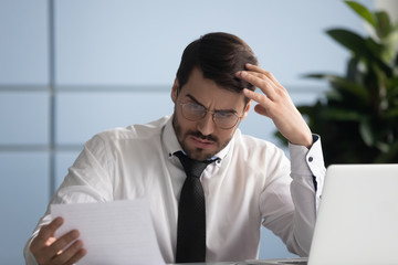 Concerned business owner reading letter from bank about financial problems