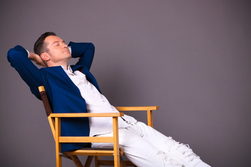 Businessman with hand behind head relaxing in a chair.