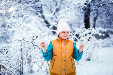 Child girl with bengal lights in winter park