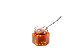 Jar with caramel spoon on a white background