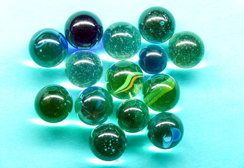 A group of glass balls on a blue background with a reflection.