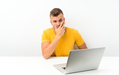 Young blonde man in a table with a laptop thinking an idea