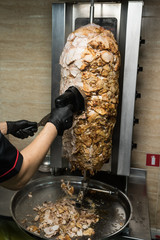 Chef hands chop chicken for doner kebab