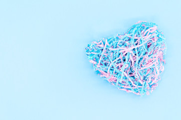 Heart shape made from shredded paper on blue background. Copy space for your text.