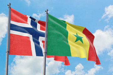 Senegal and Bouvet Islands flags waving in the wind against white cloudy blue sky together. Diplomacy concept, international relations.