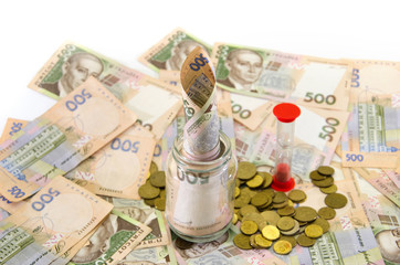 Ukrainian hryvnia, coins and hourglass. Banknotes, face value 500 hryvnia. The concept of time is money.