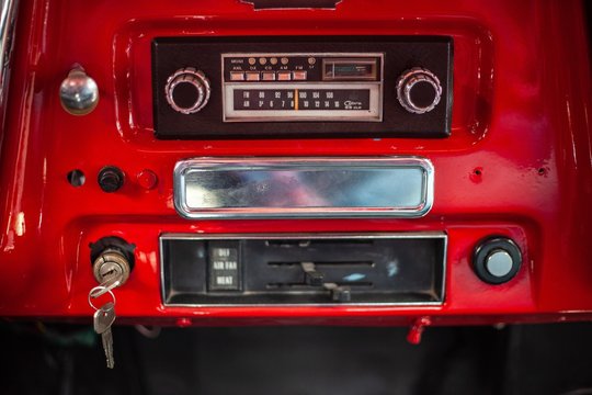 vintage radio in dashboard of red classic car