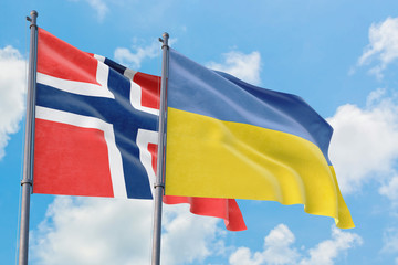Ukraine and Bouvet Islands flags waving in the wind against white cloudy blue sky together. Diplomacy concept, international relations.