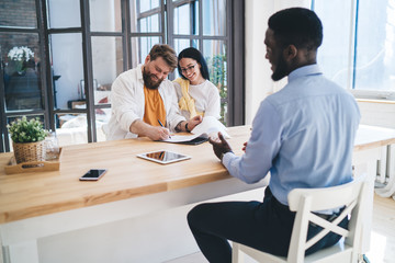 Glad couple signing papers during meeting