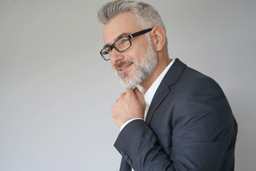 Portrait of businessman standing on grey background