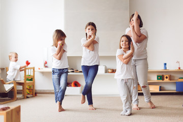 Funny children of different ages in play yoga