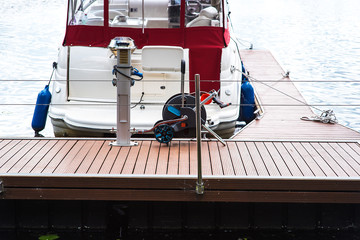 A mooring with a mooring line tied around it with boats and ships in the background in a harbour Mooring and boats in harbor