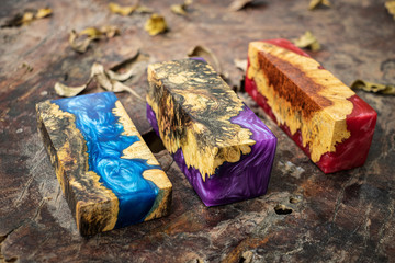 Casting epoxy resin burl wood cube on old table art background