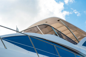 Nautical background of a row of luxury yachts, with black tinted windows and chrome metal railings on white fiber glass bows