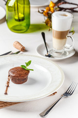 French cuisine Chocolate fondant dessert on a white plate. Baked cupcake with liquid chocolate inside. background image, copy space text