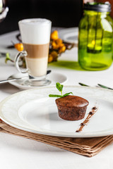 French cuisine Chocolate fondant dessert on a white plate. Baked cupcake with liquid chocolate inside. background image, copy space text