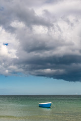 barque bleue sur une mer turquoise en Normandie