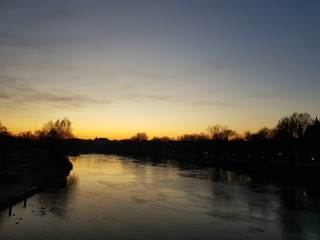 Obraz premium Sonnenuntergang auf einer Brücke auf einem Fluss im Winter