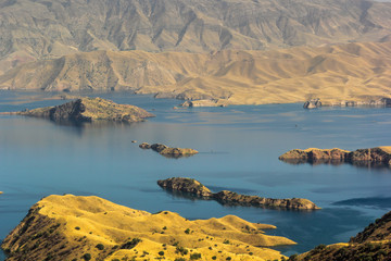 Beautiful blue waters of Nurek reservoir and golden shores