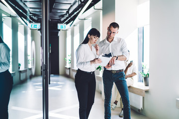 Thoughtful partners studying report at workplace