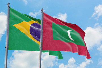 Maldives and Brazil flags waving in the wind against white cloudy blue sky together. Diplomacy concept, international relations.