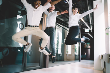 Business team celebrating success by jumping together in office