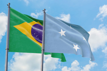 Micronesia and Brazil flags waving in the wind against white cloudy blue sky together. Diplomacy concept, international relations.