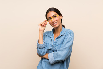 Young woman over isolated background with glasses and happy