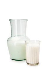 Milk in a glass decanter, glass on a white background