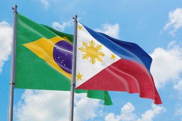 Philippines and Brazil flags waving in the wind against white cloudy blue sky together. Diplomacy concept, international relations.