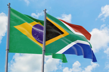 South Africa and Brazil flags waving in the wind against white cloudy blue sky together. Diplomacy concept, international relations.